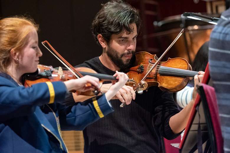 Domingo Hindoyan performing violin with the Liverpool Philharmonic Youth Orchestra