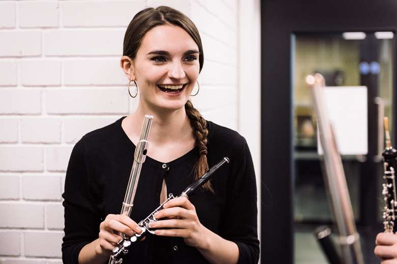 An RNCM student with a flute and a piccolo 