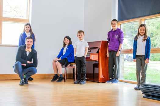 Pupils and a teacher at Hatton Park Primary School, Longstanton, with a piano donated through the Piano Equals programme