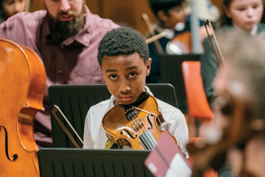 Students rehearse with the Orchestra of Opera North and In Harmony tutors for the 10th anniversary concert